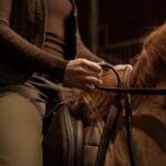 Closeup rider doing horseback over stable design interior